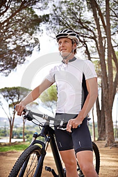 Full speed ahead. a cyclist standing with his bike outdoors.