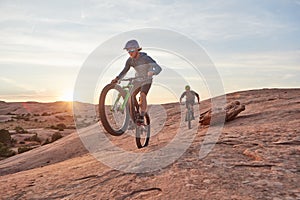 Full speed ahead. Full length shot of two young male athletes mountain biking in the wilderness.