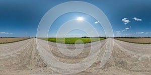 Full spherical seamless hdri panorama 360 degrees angle view on no traffic white sand gravel road  with sun on clear blue sky in