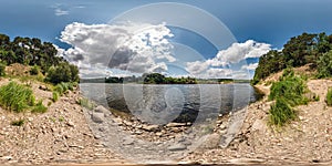 Full spherical seamless hdri panorama 360 degrees angle view on rocky shore of huge river in sunny summer day and windy weather