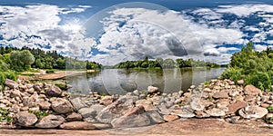 Full spherical seamless hdri panorama 360 degrees angle view on rocky shore of huge river in sunny summer day and windy weather