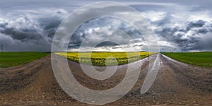 Full spherical seamless hdri panorama 360 degrees angle view on wet no traffic asphalt road near rapeseed canola fields with black