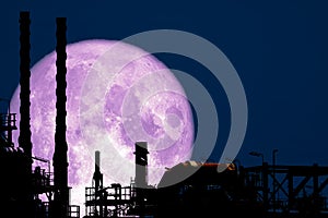 Full Strawberry Moon back on silhouette refinery on night sky