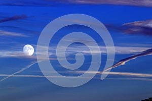 Full supermoon in dramatic blue sky and clouds