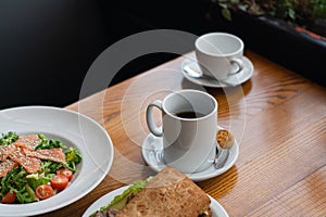 Full table of delicious and different dishes in cafe with cup of coffee in white dinnerware.