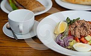 Full table of delicious and different dishes in cafe with cup of coffee in white dinnerware.