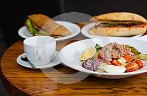 Full table of delicious and different dishes in cafe with cup of coffee in white dinnerware.