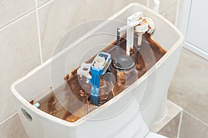 Full toilet storage tank. Open mechanism. Float valve. Scale on the walls of hard water