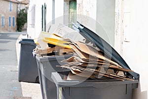 Full trash can of cardboard in street city