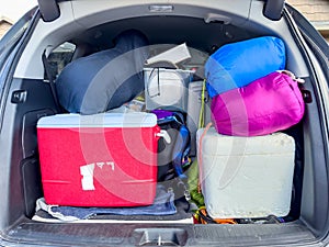 Full van packed for a camping trip with the back open.