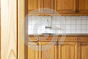 Full view of a classic wooden and kitchen with white tiled wall, retro vintage design complete furniture. close-up