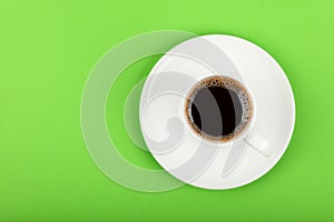 Full white espresso coffee cup over green