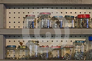A full wide shelf of jars in the back workshop