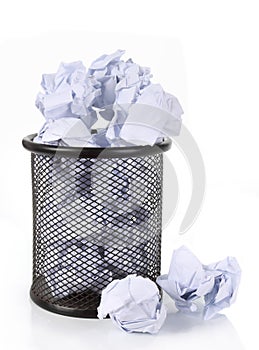 Full wire mesh trash can with crumpled paper