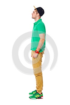 Fullbody profile portrait of young man standing in studio isolated on white.