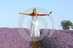 Fullbody of woman outstretching arms in lavender field