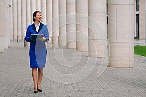 Fulllength view of a girl in a stylish suit near the business center. Admission to the position during the coronavirus
