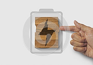 Fully charged, recharge, reboot, refresh or mindset concept. Hand putting wooden blocks with the battery charger icon on white