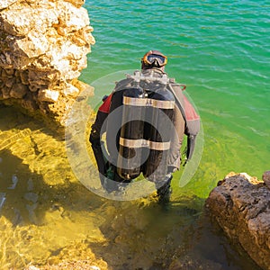 Fully equiped diver ready to dive in the sea. Close up view.