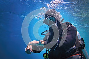 Fully equipped man scuba diver underwater in the blue water