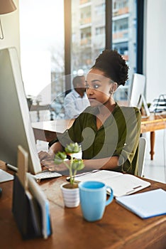 Fully focused on the task in front of her. a businesswoman working on her computer in the office.