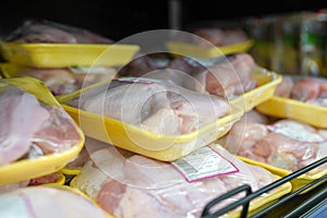 Fully loaded shelves with chicken meat in large supermarket