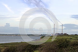 Fumes billowing from the power plant chimney stacks