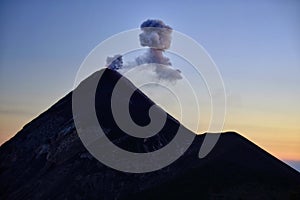 Fuming silhouette of an eruption of active volcano Fuego in Guatemala. photo