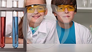 Fun chemistry class - kids giggle in protective glasses