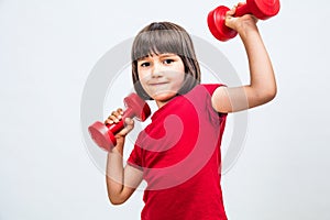 Fun child enjoying raising hands with dumbbells expressing proud success