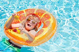 Fun child portrait. Kid boy relaxing in pool. Child swimming in water pool. Summer kids activity, watersports.