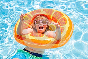 Fun child portrait. Young boy kid child splashing in swimming pool. Active healthy lifestyle, swim water sport activity