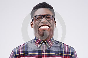 Fun comes first. Studio shot of a young man making a funny face against a gray background.