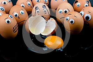 Fun concept: raw eggs with googly eyes and drawn features in shock witness another egg broken in front of them