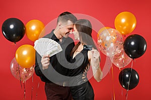 Fun couple celebrating birthday holiday party hold lot cash money, credit card isolated on bright red background air