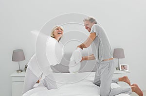 Fun couple having a pillow fight