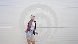 Fun dance of a trendy teenager. Happy healthy girl dancing outdoors on a city street, having fun, laughing. The concept