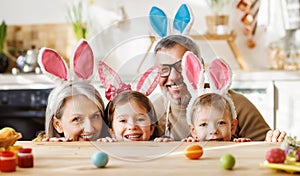 Happy family grandparents and grandchildren having fun while painting Easter eggs together