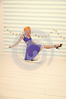 Fun and entertainment. Girl wig rides swing little horse. Feel childish. Lady red or ginger wig blue dress rides rocking