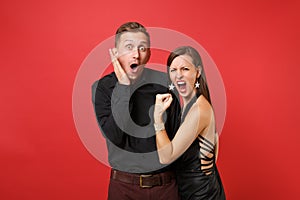 Fun expression young couple in black clothes shirt dress celebrating birthday holiday party on bright red