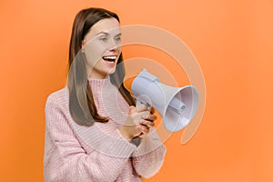 Fun expressive happy smiling student caucasian female 20s scream aside shouting in megaphone, dressed in pink knitted sweater