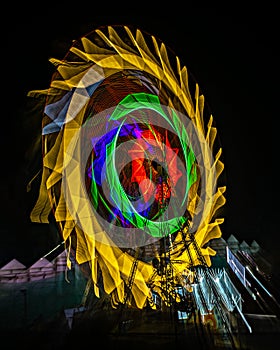 Fun fair Giant Colorful Ferris wheel spinning at night