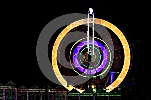 Fun fair Giant Ferris wheel spinning at night. Slow shutter photograph of a rotating giant wheel at night.