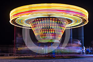Fun-fair at long exposure. Light trails motion. Carousel lights and movements.
