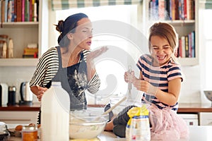 Fun with flour. Shot of a little girl baking with her mother in the kitchen.