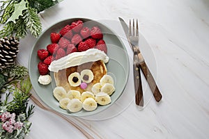 Fun food for kids. Christmas Santa pancake with raspberry and banana for children menu, top view with copy space