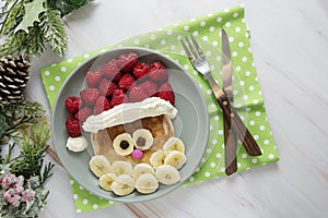 Fun food for kids. Christmas Santa pancake with raspberry and banana for children menu, top view with copy space