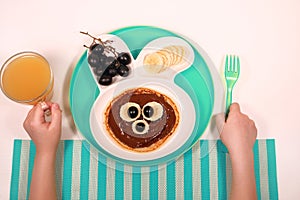 Fun food for kids. pancakes with grapes and banana in a rabbit-shaped plate