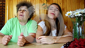 Fun and funny grandmother and granddaughter singing and dancing