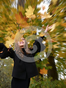 Fun girl tosses fall foliage
